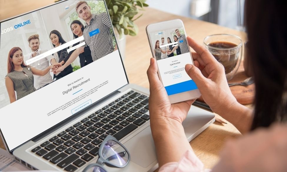 Job seeker browsing a digital recruitment website on laptop and smartphone — online job search and digital hiring platforms.
